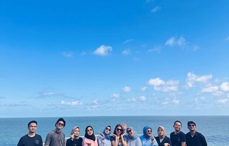 Rombongan privat trip menikmati pemandangan indah di Pantai Selatan Gunungkidul Yogyakarta, destinasi populer untuk liburan Jogja.